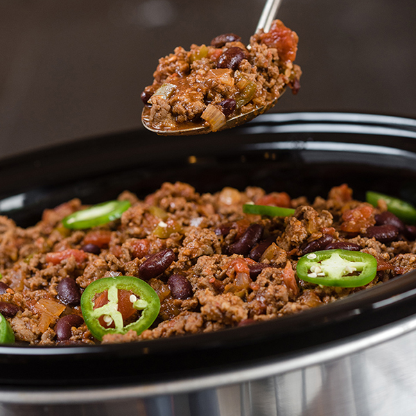 chili being spooned from a slow cooker